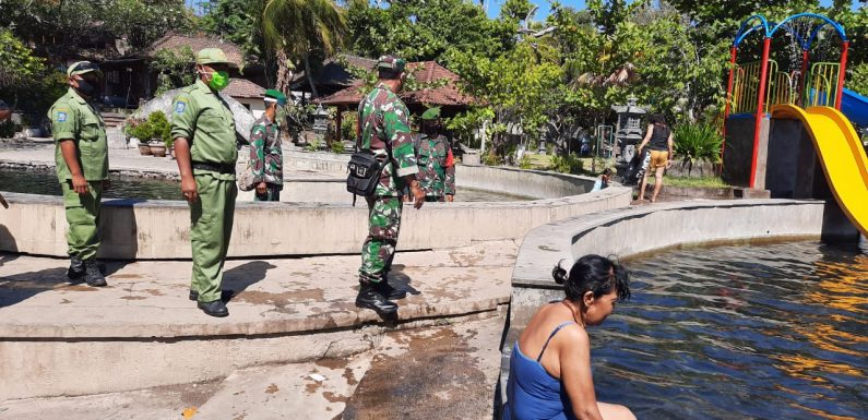 Aparat TNI Bersama Linmas Dan Pecalang Ingatkan Pengunjung Wisata Air Sanih Terkait Protokol Kesehatan.
