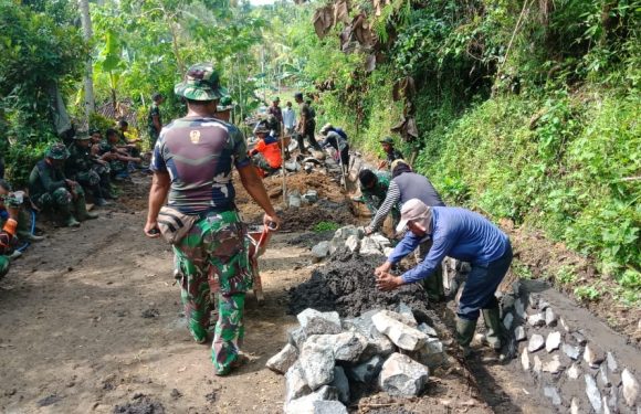 Personel Satgas TMMD Bersama Warga Bahu Membahu Kerjakan Senderan Saluran Air.