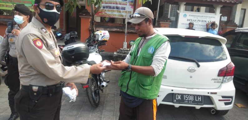 Cegah Penyebaran Covid-19 Klaster Pasar Adat, Personil Polsek Kuta  Bagikan Masker Gratis.