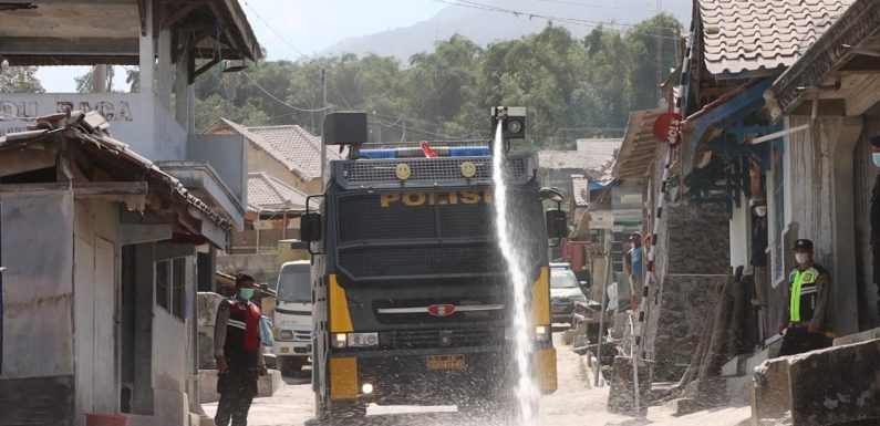 Polisi Bantu Bersihkan Jalan, Dampak Abu Vulkanik Pasca Erupsi Merapi.